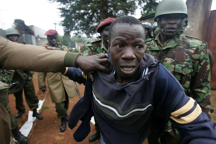 En oppositionstilhænger anholdes af politi i slumområdet Kibera i Nairobi. 