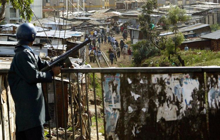 En kenyansk politimand overvåger en forsamling af oppositionstilhængere i slumområdet Kibera i Nairobi. 