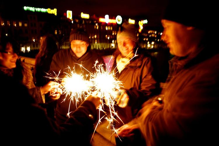 På tærsklen til år 2008 tænder feststemte mennesker stjernekastere på Dronning Louises Bro 