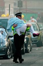 Politibetjent bærer kræftpatient ud fra brændende hospital i London. 