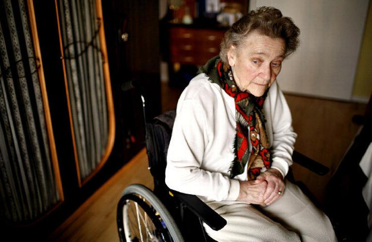 Ursula Lundqvist kan kun gå få skridt med sine tunge benproteser. Mens hun genoptræner og drømmer om en el-scooter, tilbringer hun det meste af tiden i sin kørestol.  Foto: Jonathan Bjerg Møller 