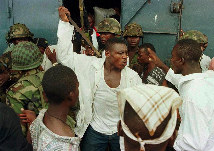 Joshua Milton Blahyi, kendt som general Butt Naked, beder om tilgivelse for 20.000 drab. Her truer han en af sine allierede under et skænderi i 1996. 