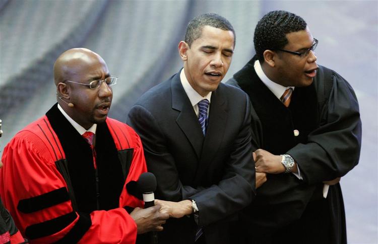 Barack Obama synger 'We shall overcome' med Raphael Warnock (højre) og pastor Shanan Jones (venstre) i Atlanta. 