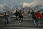 Børn leger på en del af det ødelagte grænsehegn mellem Gaza og Egypten. Egyptiske vagter blokerer nu hullerne i hegnet. 