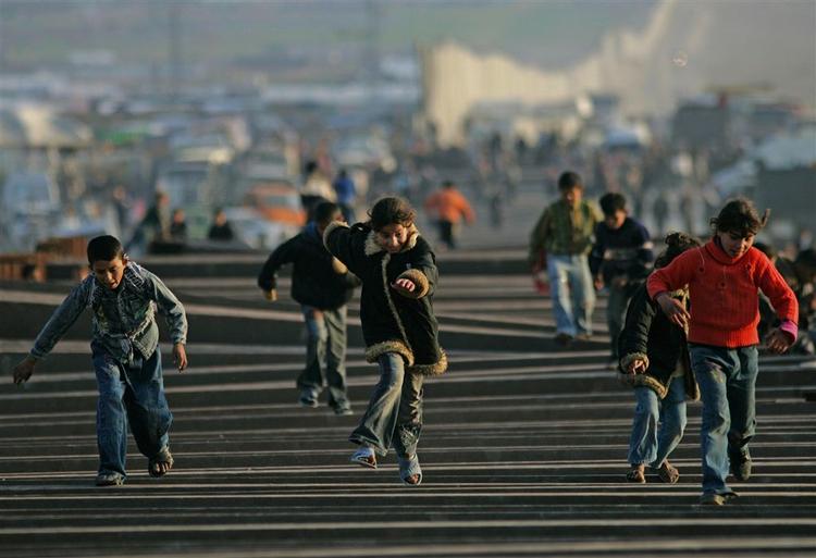 Børn leger på en del af det ødelagte grænsehegn mellem Gaza og Egypten. Egyptiske vagter blokerer nu hullerne i hegnet. 