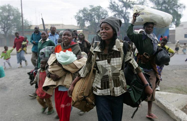 Kenyanere flygter under politieskorte fra Naivasha i det vestlige Kenya, hvor bander er gået amok i blodrus. 