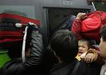 Passagerer forsøger at presse sig ind i en bus, der skal bringe dem ud af Guangzhou, hvor tusindvis af kinesere er strandet på grund af det dårlige vejr. 