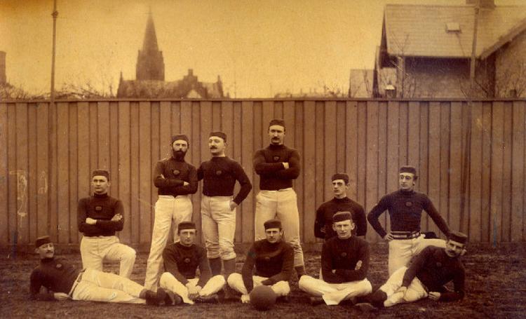 I 1886 havde KB endnu ikke fået de senere så karakteristiske blå og hvid-stribede trøjer. I dansk fodbolds første år var holdenes spilledragter som regel ens, så det var på hattefarven, man kunne kende forskel på de to hold. Foto fra bogen. 
