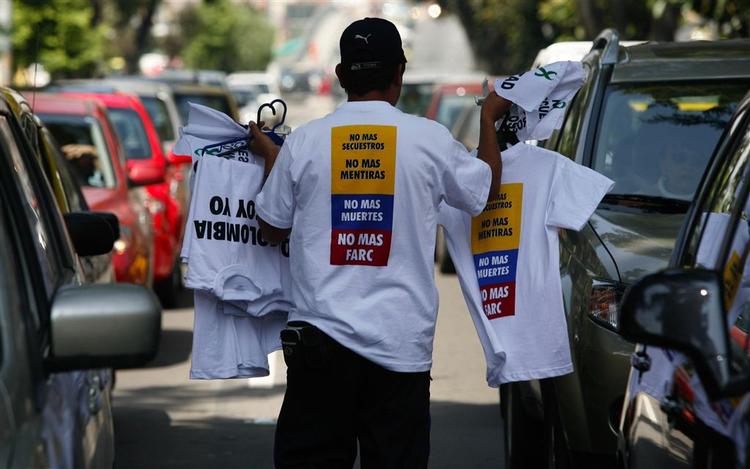 En mand i Bogota sælger T-shirts, hvor FARC-oprørere opfordres til at standse kidnapninger. 
