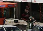 En israelsk politimand råber ordrer ved det sted, hvor et selvmordsangreb i går dræbte en israelsk kvinde. 