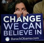 En Obama-tilhænger titter frem bag et skilt med sloganet 'Change We Can Believe In'. Og demokraterne rider på en bølge af entusiasme på grund af netop kravet om forandring, mener redaktør på Washington-baseret avis. 