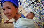 En flygtning fra Hmong-stammen bærer et lille barn på ryggen. Hun er en af de mange fra sin stamme, der flygtede til Thailand for at undgå forfølgelse i Laos. 