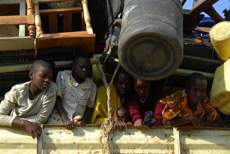 Børn følger med fra bagsmækken af en bil, der er ved at forlade en midlertidig flygtningelejr i nærheden af Kenyas tredjestørste by, Kisumu. 