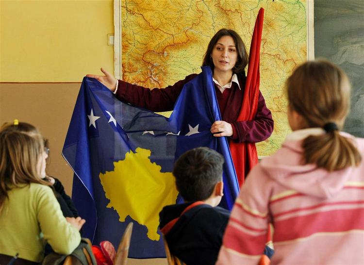 En kosovaalbansk skolelærer præsenterer det nye flag for Kosova for eleverne. 