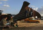 Palæstinensere sidder ved den del af grænsehegnet, der blev ødelagt i januar mellem Gaza og Egypten. 