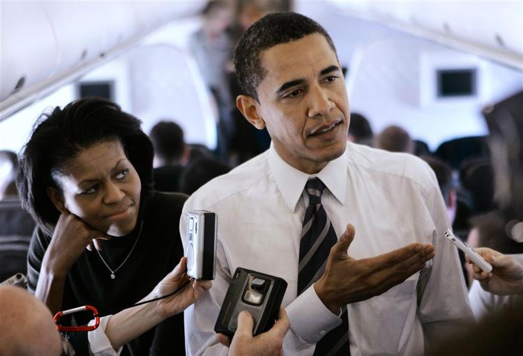 Barack Obama og hans kone Michelle ankommer her til San Antonio, hvor han - og Hillary Clinton - fylder det meste af bybilledet. 