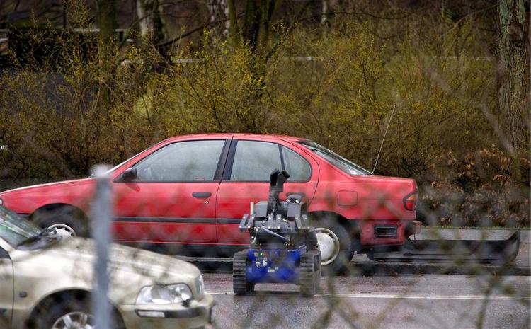 Svensk politi modtog flere bombeadvarsler i Malmø, samtidig med at maskerede mænd røvede en bank. Her nærmer en bomberobot sig bilen, hvor en lille eksplosion skete. 