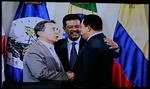 Colombias præsident, Alvaro Uribe (tv.) fik trykket hånd med Venezuelas præsident, Hugo Chavez, der har sendt soldater mod grænsen mellem de to lande. Den Dominicanske Republiks præsident, Leonel Fernandez (i midten) glæder sig over forsoningen. Billedet er fotograferet fra en storskærm uden for topmødets lokaler. 