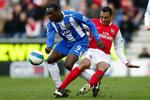 Wigans Emille Heskey (tv.) tackles af Arsenals Gilberto. 