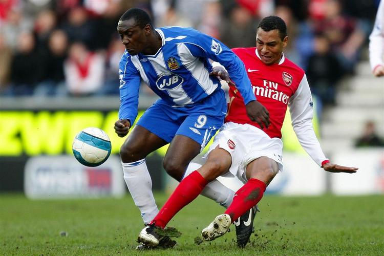 Wigans Emille Heskey (tv.) tackles af Arsenals Gilberto. 