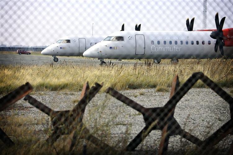 En gruppe af SAS' 27 passagerfly af typen Bombardier Dash 8 Q400 står stille i Københavns lufthavn på dette arkivfoto. 
