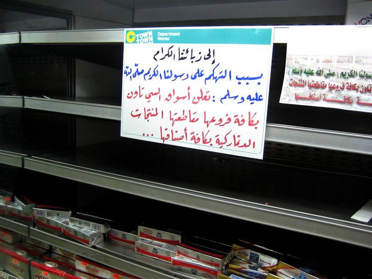 På de tomme hylder i supermarkedet i Amman skulle der have været dansk smør. Men sedlen fortæller i stedet, at danske varer boykottes på grund af »latterliggørelsen af vores kære profet«. Arkivfoto. 