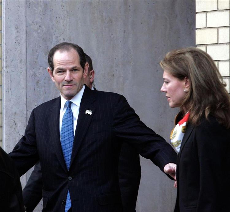 Eliot Spitzer og hans kone Silda Hall Spitzer forlader i går deres lejlighed på Manhattans Fifth Avenue for at tage til den pressekonference, hvor Spitzer meddelte sin afgang. 