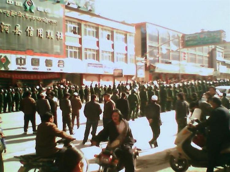Kun få billeder er sluppet ud fra Tibet. Dette er taget med mobiltelefon  og viser tibetanere omgivet af massivt opbud af kinesiske sikkerhedsstyrker. 