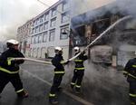 Brandmænd forsøger at slukke en antændt brand i Tibets hovedstad Lhasa, hvor anti-kinesiske demonstrationer blev voldelige. 