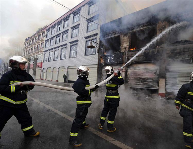 Brandmænd forsøger at slukke en antændt brand i Tibets hovedstad Lhasa, hvor anti-kinesiske demonstrationer blev voldelige. 