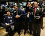 Børsmæglere på børsen i New York ser på centralbankens offentliggørelse af rentesænkningen. 