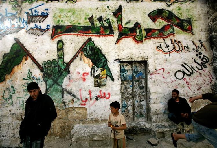 Palæstinenserne støtter Hamas' raketter mod Israel og en fortsat voldelig kamp. Skriften på husvæggen i Gaza er de arabiske tegn for 'Hamas'. 