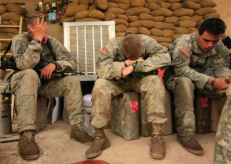 Dødstallet for dræbte amerikanske soldater i Irak har nu rundet 4000. Her ses tre amerikanske soldater, der sidder udmattede efter deres søgen efter forsvundne kammerater. 
