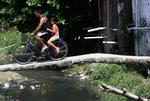 Dengue-feber overføres fra myg, der har gode livsbetingelser i de mange åbne vand- og kloakkanaler tæt ved bebyggelser. Her kører brasilianere over en åben kloak i slumområdet Curicica i Rio de Janeiro. 