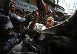 Politiet anholder en demonstrant under dagens uroligheder i Kathmandu. 