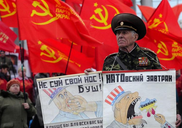 En demonstrant i Ukraines hovedstad protesterer mod NATO's planer om at udvide forsvarsspagten med netop Ukraine og Georgien. 'Bush, hold næsen væk' og'NATO's frokost' står der på hans plakater. 