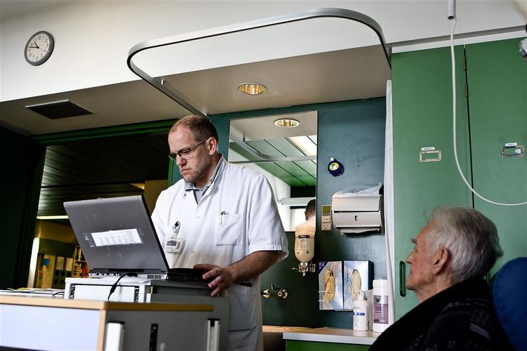 Overlæge Jens-Ulrik Rosholm på stuegang med sin computervogn hos 88-årige Ejvind Larsen på Odense Universitetshospital. 