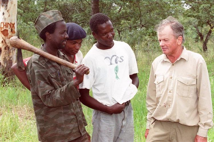 Mugabe-støtter har invaderet en gård ejet af en hvid mand i Zimbabwe. Her et arkivbillede fra marts 2000, hvor Mugabe-støtter besatte de hvides gårde og fik dem til at forlade området. 