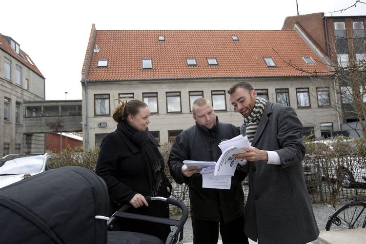 En lille familie får udleveret plakater og løbesedler mod et ungdomshus på Dotheavej. Dem vil de fordele i kvarteret. Fra venstre er det Ida Svane-Rasmussen, Thomas Dollas og den konservative ungdomspolitikerMorten Kornbech Larsen. Bag dem ses det måske kommende ungdomshus på Dortheavej 61. 