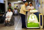 En sygeplejerske på et hospital i Aizu Wakamatsu i Japan får hjælp fra en robot (arkivfoto). 