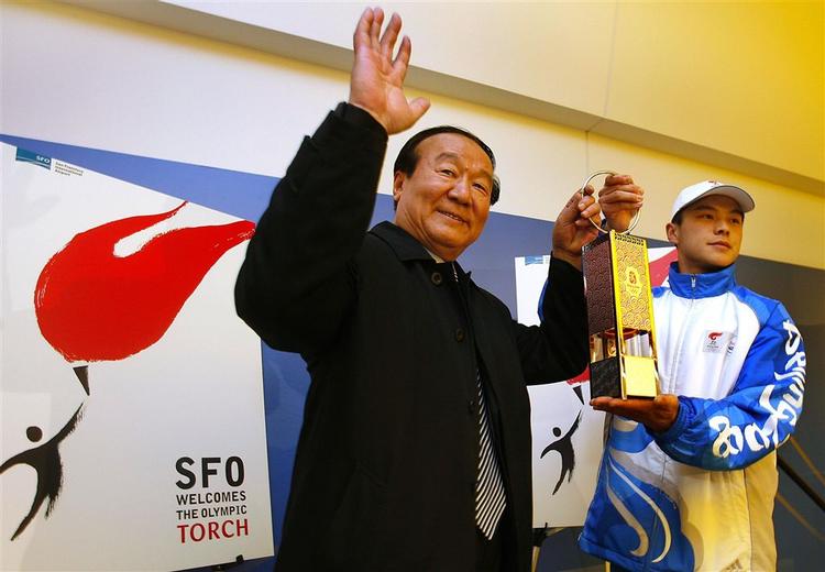 Jiang Xiaoyu, vicepræsident for Beijings Olympiske planlægningskomité, vinker og viser flamme til pressen efter ildens ankomst til San Francisco Internationale lufthavn. 