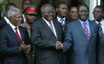 Den Kenyanske præsident Mwai Kibaki trykker Raila Odingas hånd. Odinga har i dag fået posten som premiereminister. 