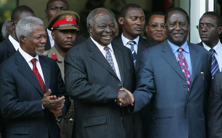 Den Kenyanske præsident Mwai Kibaki trykker Raila Odingas hånd. Odinga har i dag fået posten som premiereminister. 