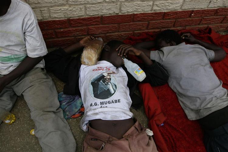Gadebørn i Harare med propaganda for præsident Robert Mugabe på T-shirten hviler sig midt på dagen. 