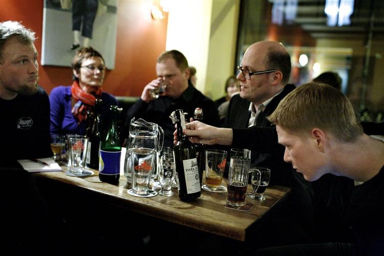 Øl-entusiaster smager på dråberne ved en tidligere lejlighed på Ølbaren på Nørrebro. 