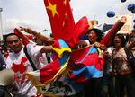 Pro-kinesiske aktivister fjerner et tibetansk flag under den olympiske fakkelceremoni i Malaysias hovedstad. 