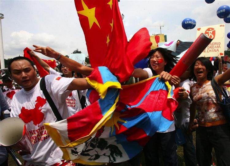Pro-kinesiske aktivister fjerner et tibetansk flag under den olympiske fakkelceremoni i Malaysias hovedstad. 