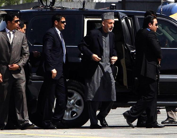 Hamid Karzai (nummer to fra højre) blev ført væk fra paraden af livvagter. 