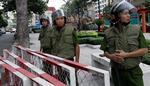 Vietnamesiske politifolk er klar til at håndtere ballade fra demonstranter foran Operahuset i Ho Chi Minh City, før OL-ildens stafet gennem byen tirsdag aften. 