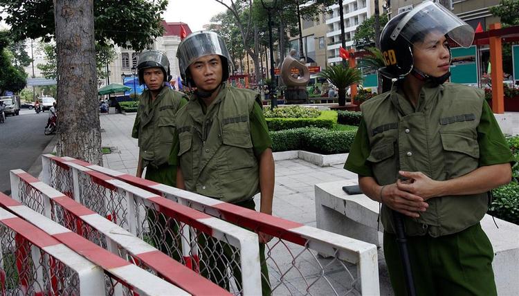 Vietnamesiske politifolk er klar til at håndtere ballade fra demonstranter foran Operahuset i Ho Chi Minh City, før OL-ildens stafet gennem byen tirsdag aften. 